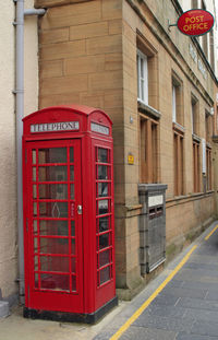 Red telephone booth on sidewalk