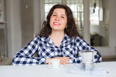 Portrait of smiling woman sitting at cafe