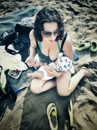 Woman breastfeeding son at beach