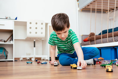 Boy playing with toy cars at home