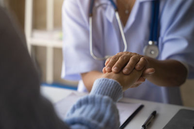 Midsection of doctor examining patient in hospital