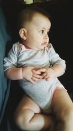 Close-up of baby girl sitting on sofa