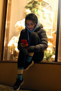 Portrait of young woman sitting at home