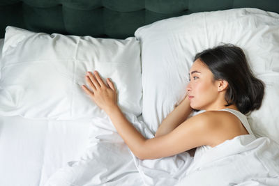 Young woman sleeping on bed at home