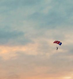 Low angle view of person paragliding against sky