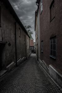 Walkway in town against sky