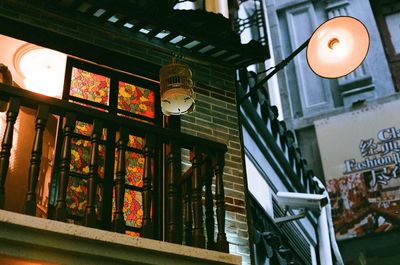 Low angle view of illuminated lanterns hanging by building