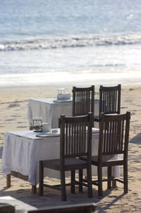 Tables and chairs arranged at beach