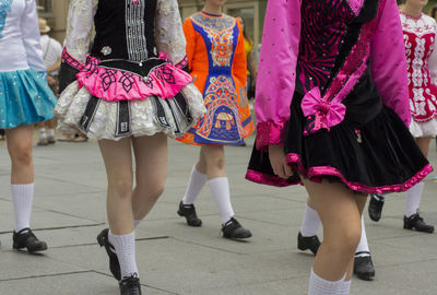 Low section of people in traditional clothing walking on street in city