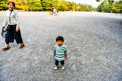 Portrait of smiling boy standing on gravel