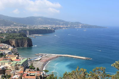 High angle view of townscape by sea against sky