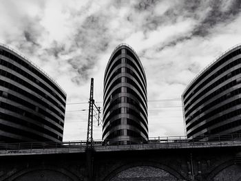 Low angle view of modern building against cloudy sky