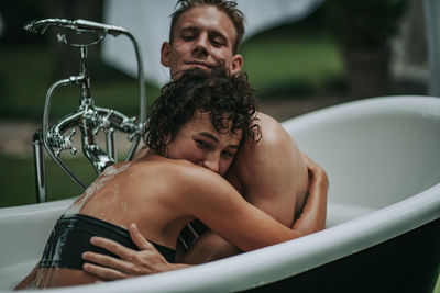 Young couple sitting in bathroom