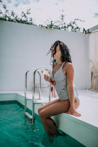 Woman sitting in swimming pool