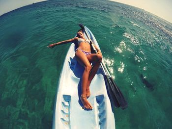 High angle view of woman lying down in boat on sea