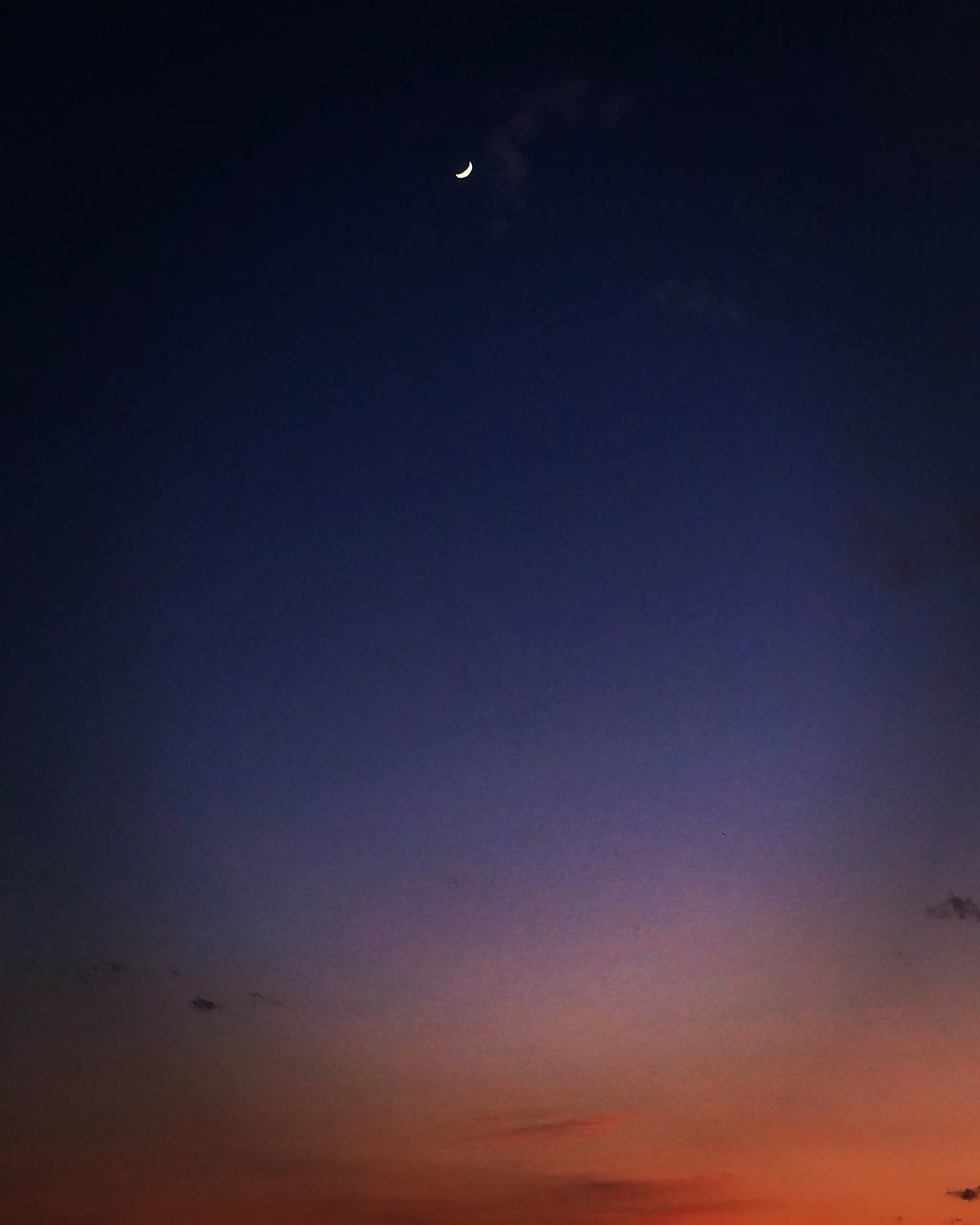 LOW ANGLE VIEW OF MOON IN SKY AT SUNSET