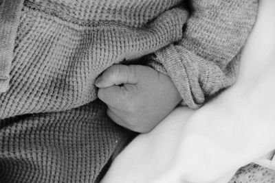 Cropped hand of baby in warm clothing