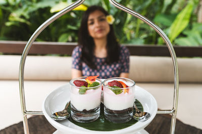 Portrait of smiling woman with ice cream on table