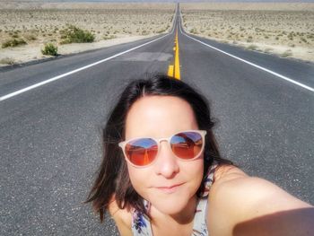 Portrait of woman with sunglasses on road