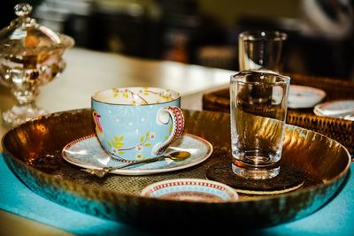 Tea cup by glass in tray on table
