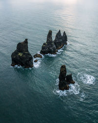Rock formation in sea against sky