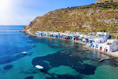 Scenic view of houses by sea against mountain