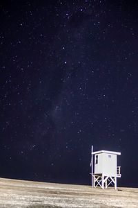 Lifeguard hut against sky at night