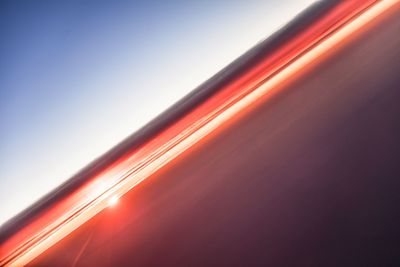 Blurred motion of illuminated car against sky during sunset