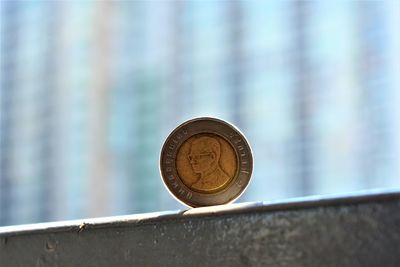 Close-up of coin on metal against wall