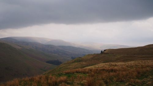 Scenic view of mountain against cloudy sky