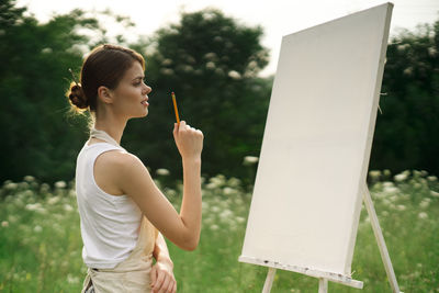 Side view of young woman using mobile phone