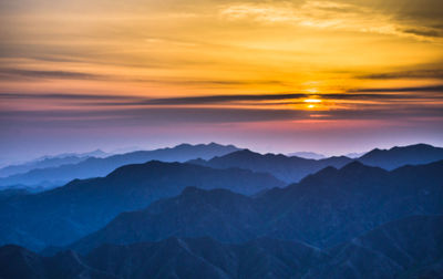 Scenic view of landscape against dramatic sky during sunset