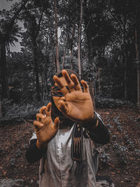 Midsection of person standing by plants in forest