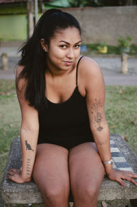 Portrait of young woman sitting outdoors