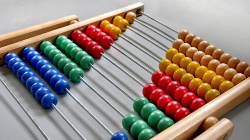 Close-up of multi colored beads against gray background