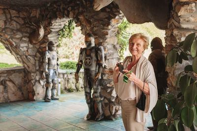 Senior tourist woman taking photo on her phone in ancient castle