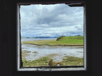 Scenic view of sea seen through glass window