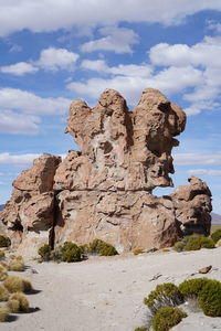 View of rock formation against cloudy sky