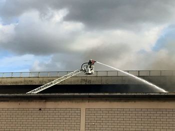 Low angle view of man working against sky