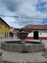 Houses in town against cloudy sky