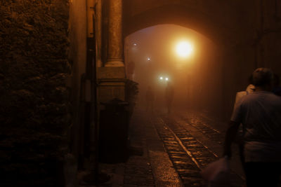 Man and illuminated railroad tracks at night