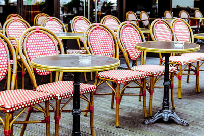 Empty tables and chairs at sidewalk cafe