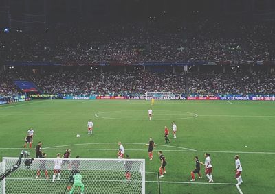 Group of people playing soccer on field