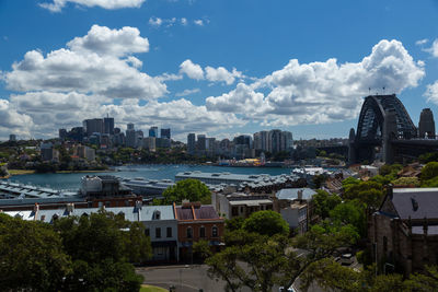 Cityscape by river against sky