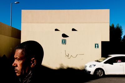 Man standing by car against sky