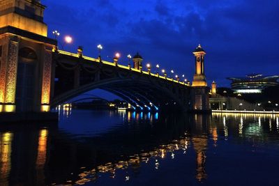 Illuminated bridge over river at night