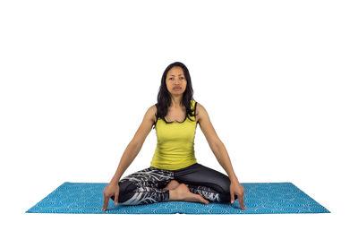 Portrait of woman sitting against white background