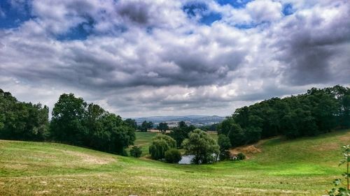 Scenic view of grassy field against cloudy sky