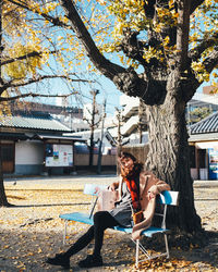 Portrait of man sitting on tree trunk