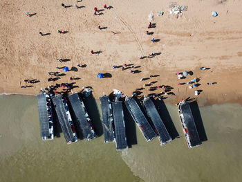 Aerial top down view fishing boat and crowd buying seafood.